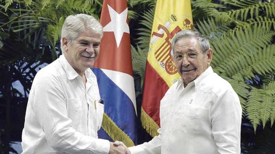 Raúl Castro (dcha.) estrecha la mano del ministro de Exteriores español, Alfonso Dastis. // Efe