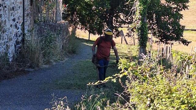 Un vecino de la parroquia cruceña de Merza desbrozando un vial con medios propios. |