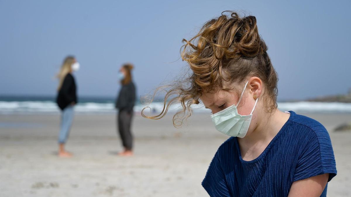 Una niñas con mascarilla en una playa de A Coruña.
