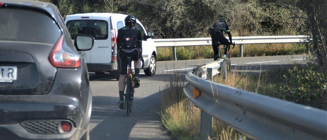 Automobislistes i ciclistes conviuen amb dificultats a la carretera de Roses a Cadaqués.