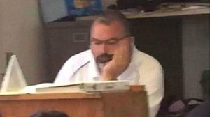 Un professor és gravat pels alumnes mentre mira pàgines de llenceria a la classe.