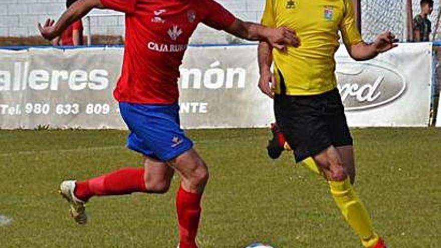 Un jugador del CD Benavente pelea un balón ante un contrincante.