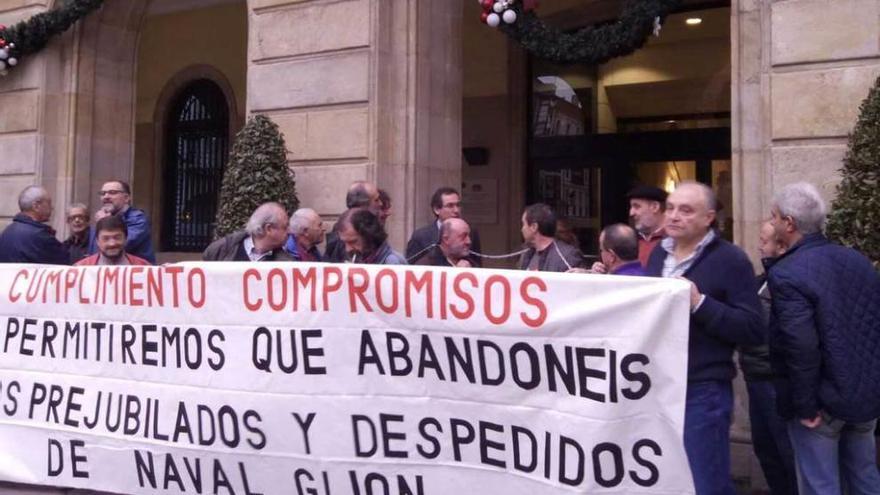 Despedidos y jubilados de Naval Gijón se encadenan en el Ayuntamiento