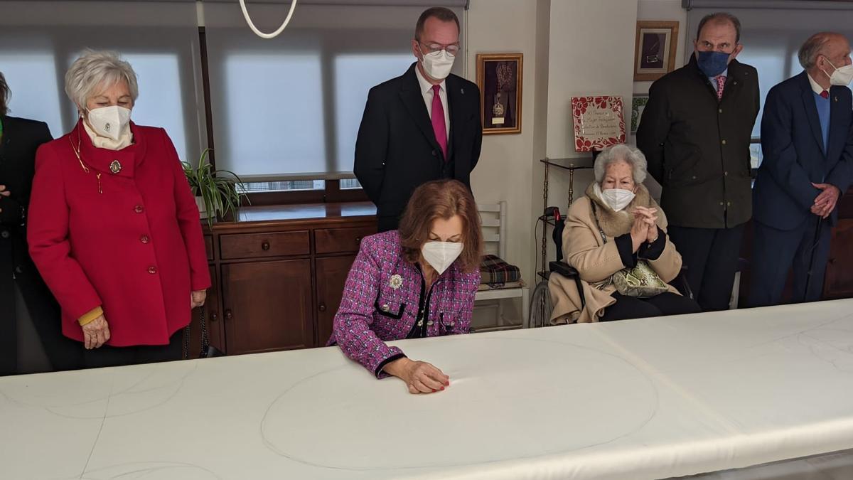 La que fuera presidenta del Coro de Damas de la Virgen de la Amargura, María del Carmen Gallego Ramírez, dando el primer punto al segundo manto de la titular del Paso Blanco, en marzo pasado.