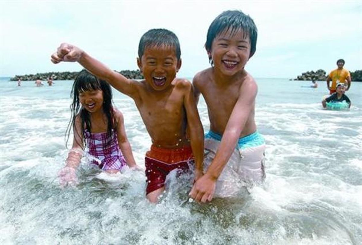 Tres nens es diverteixen, ahir, a la platja d’Iwaki, a la prefectura de Fukushima, a 65 quilòmetres de la central.