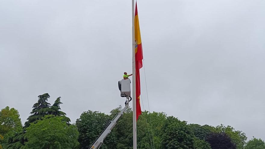 Los operarios cambiando la bandera de España.