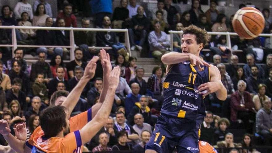 Sergio Llorente da un pase entre tres rivales del Palencia, ayer en el polideportivo de Pumarín.