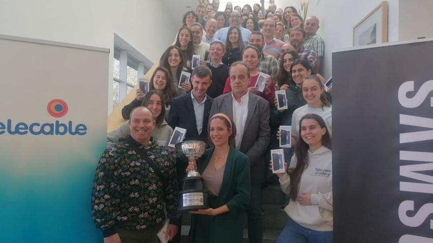 La plantila del Telecable Gijón junto a los trabajadores de la firma patrocinadora en el homenaje de ayer. |