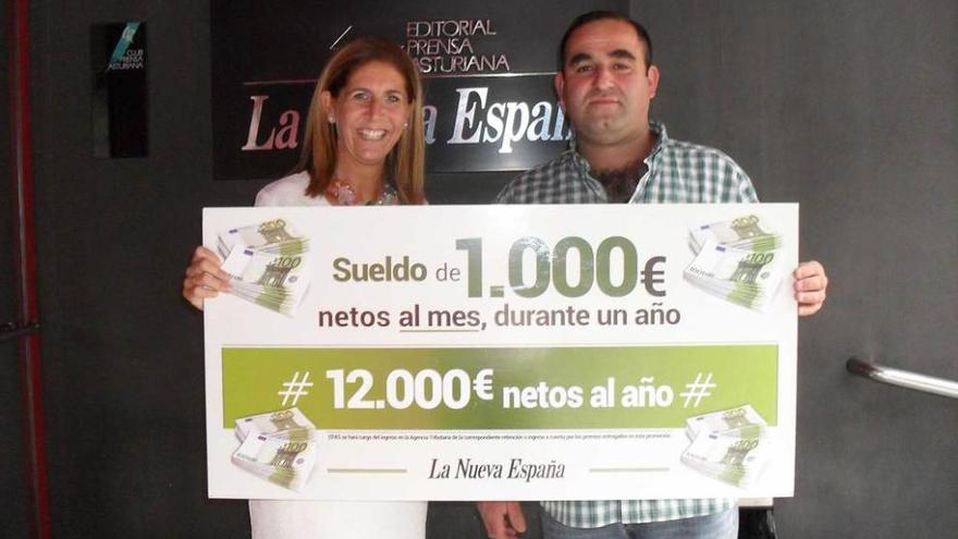 Luisa María López, directora comercial de LA NUEVA ESPAÑA, entrega el cheque al premiado, Daniel Suárez.