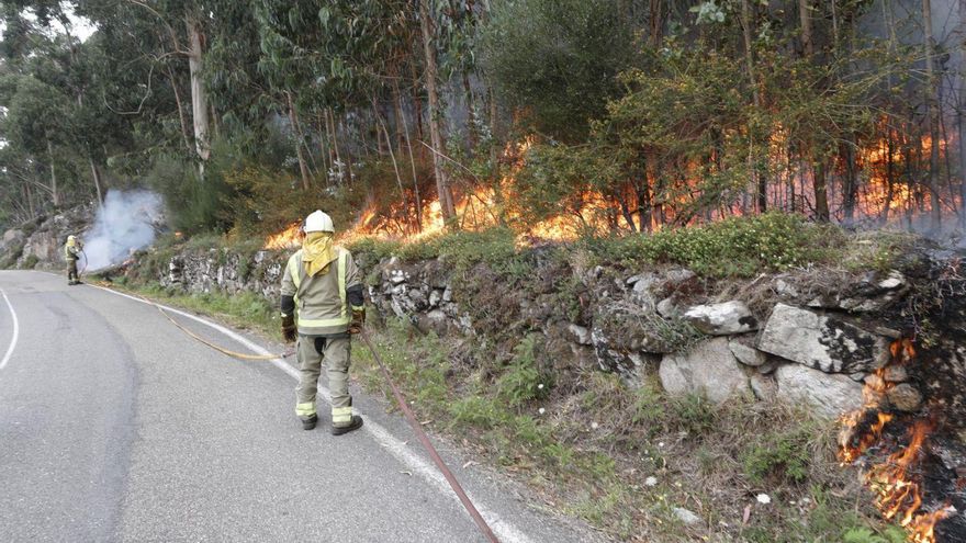 Bomberos trabajando en las labores de extinción del fuego que calcinó 50 hectáreas en Baredo. // R. GROBAS