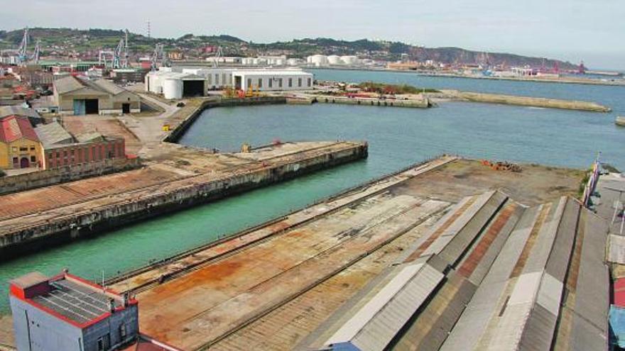 En primer término, Naval Gijón, con el dique inundado y sin grúas.