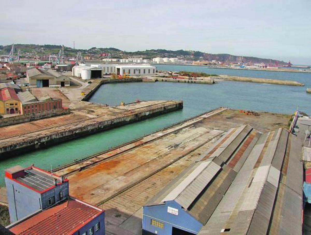 En primer término, Naval Gijón, con el dique inundado y sin grúas.