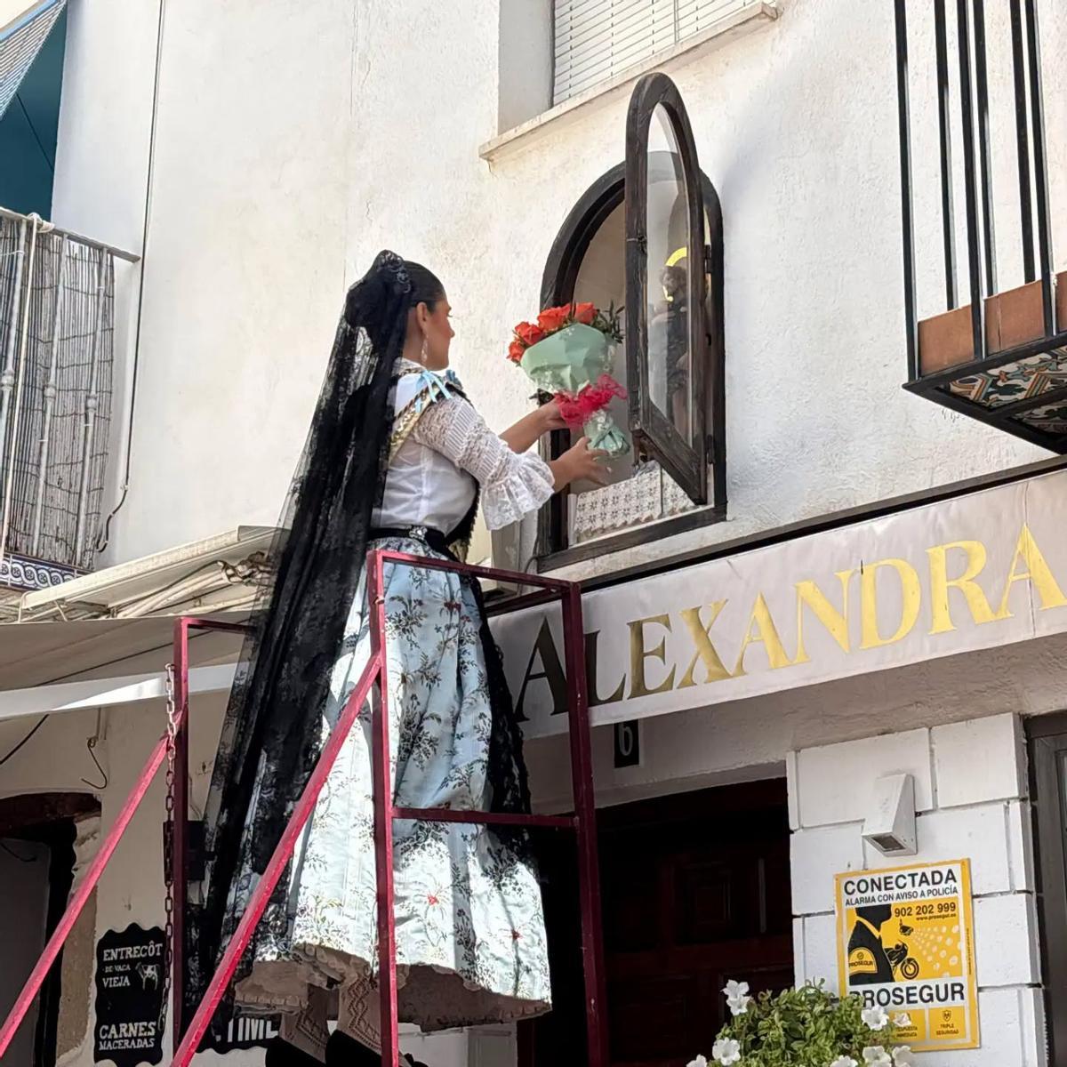 La reina 2025 colocando el ramo de flores en la imagen de San Roque.