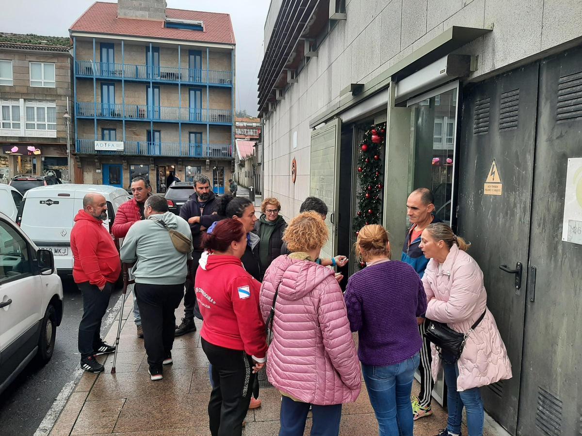 Marineros y pescantinas ayer delante del acceso de la plaza de Bueu junto al concejal Ricardo Verde.