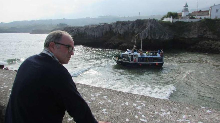 José del Rosal, observando la embarcación cántabra &quot;Cacheria Segundo&quot;, encallada ayer en Llanes.