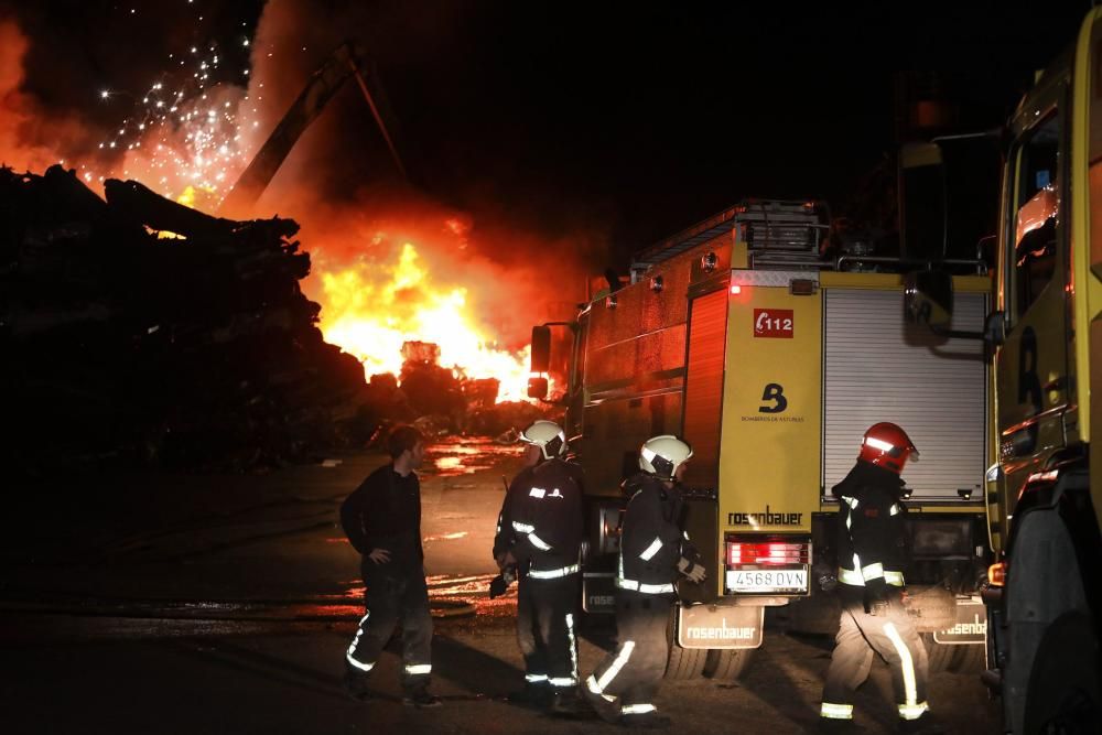 Labores de extinción del incendio de un desguace en Gijón