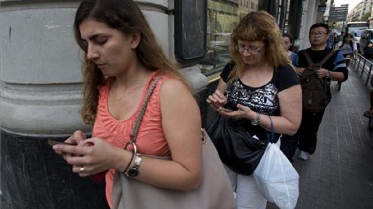 Usuarios de 'smartphones' chateando mientras caminan