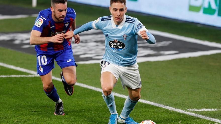 Emre Mor conduce el balón ante la atenta mirada de Edu Expósito.