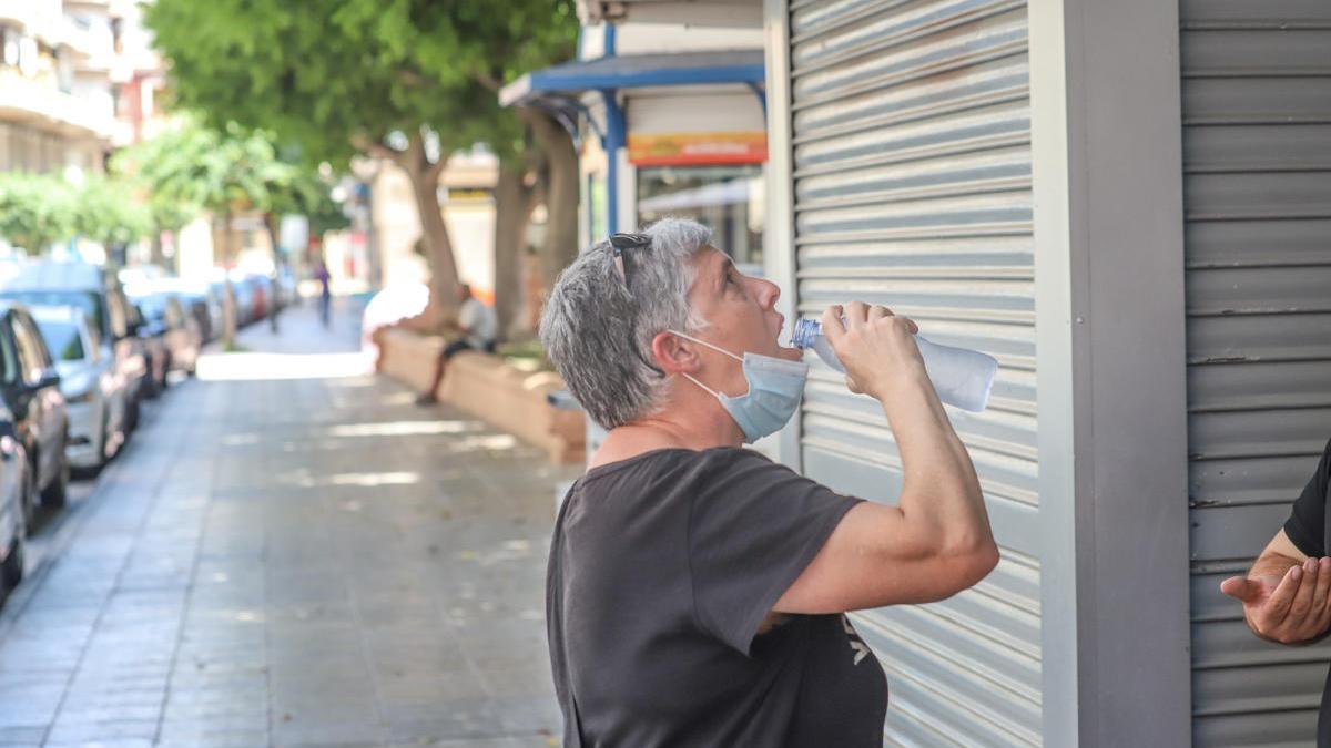 Una persona bebe agua en Orihuela, donde se han alcanzado 38 grados. TONY SEVILLA