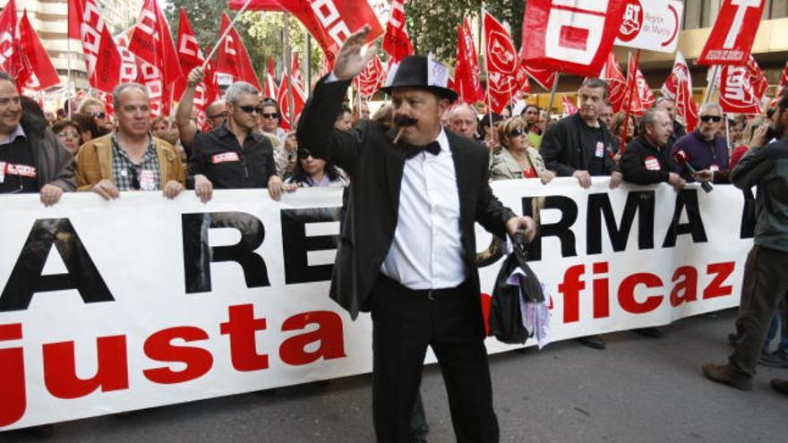 Un ciudadano vestido con traje, pajarita y bombín parodia a los grandes banqueros en el inicio de la manifestación de ayer en Murcia