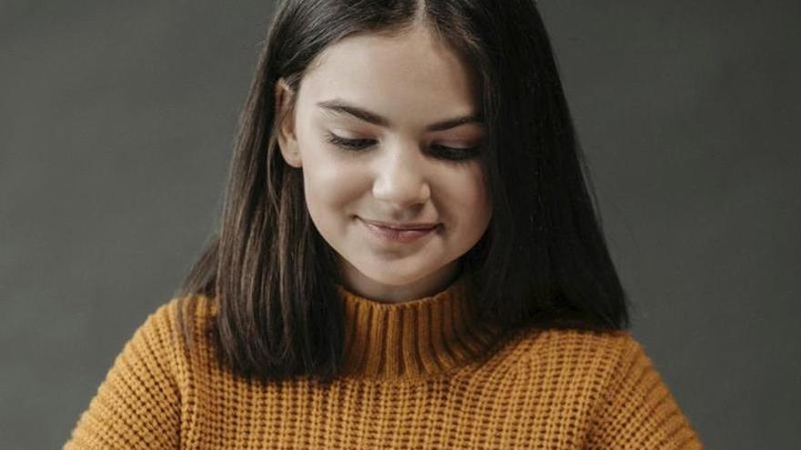 Una adolescente, leyendo un libro.