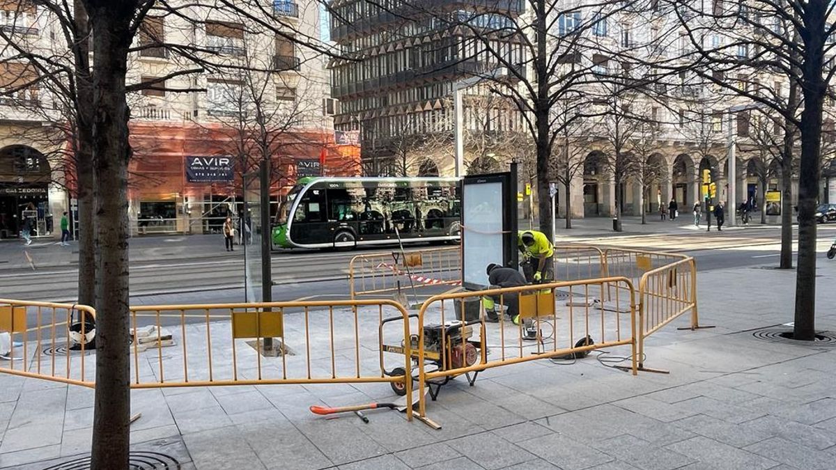 Dos operarios retiran este miércoles por la mañana una de las marquesinas de Independencia.