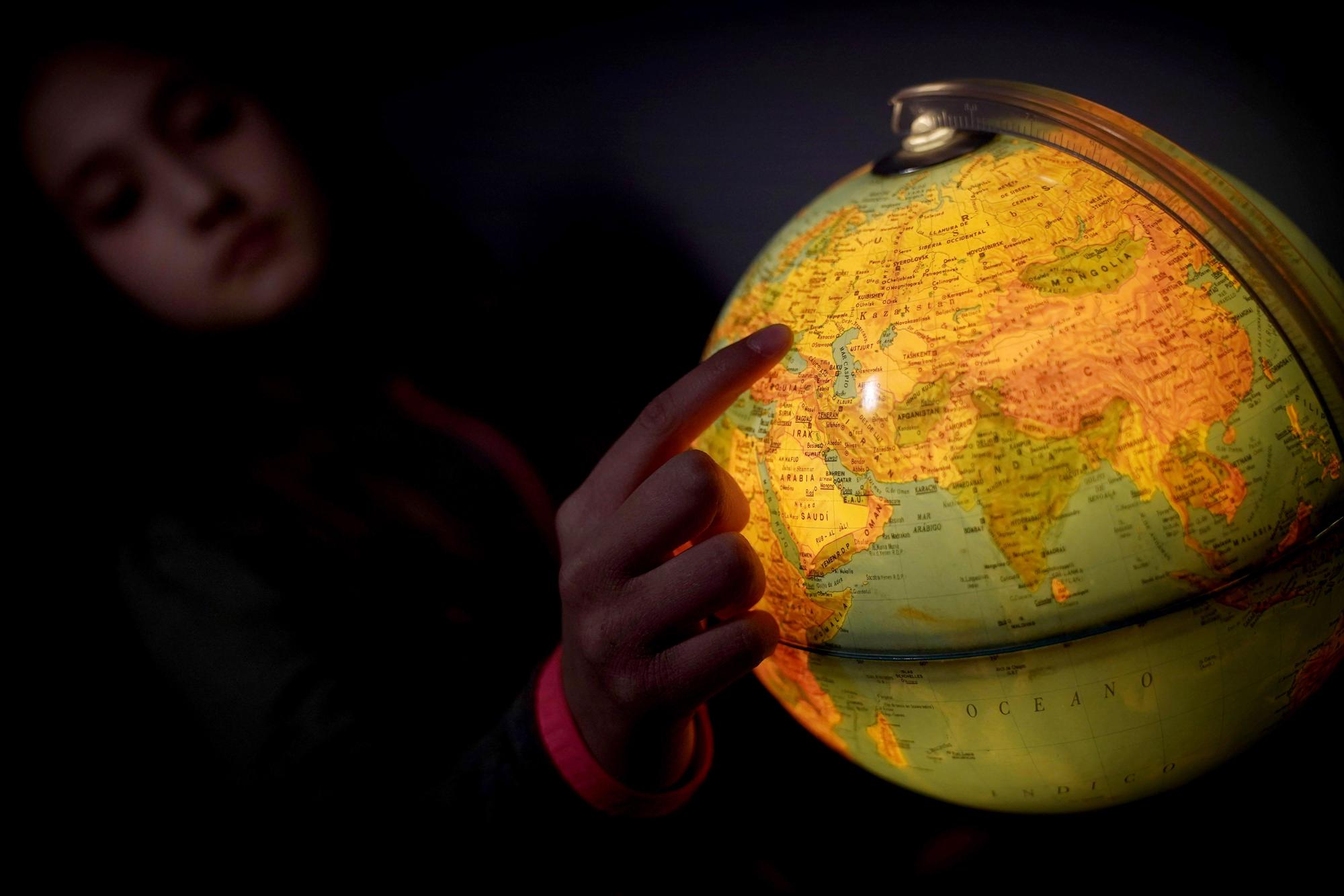 Una niña señala Ucrania en un globo terráqueo FOTO JOSÉ LUIS ROCA