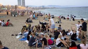 Al atardecer de la noche de Sant Joan, en la playa de Sant Sebastià, la gente se prepara para la verbena