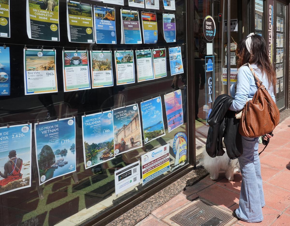 Una mujer contempla las ofertas de una agencia de viajes de Castelló.