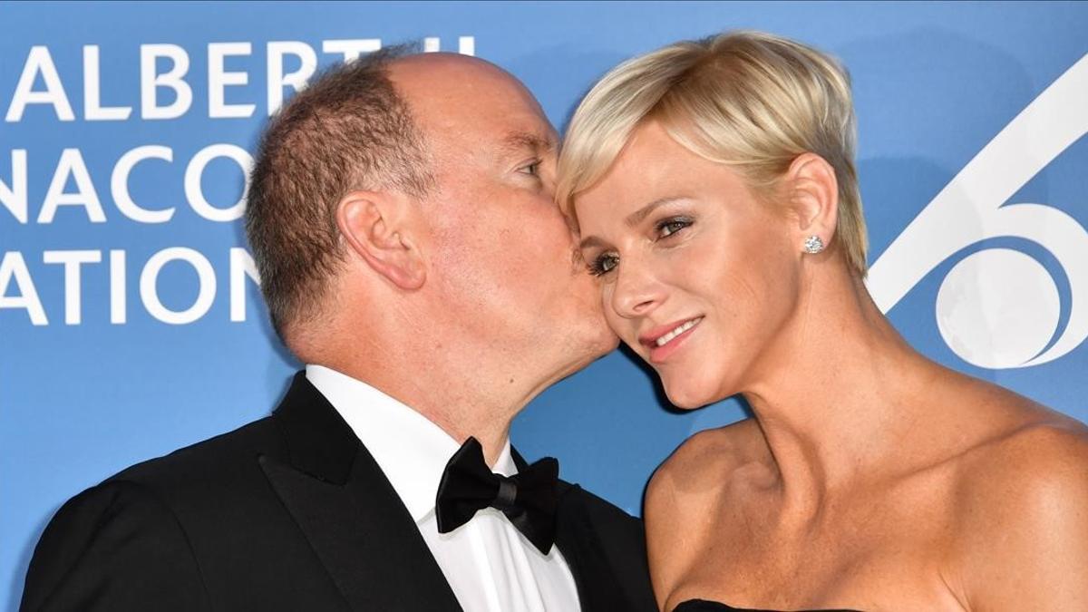 Monaco s Prince Albert (L) embraces Princess Charlene during the Monte-Carlo Gala for the Global Ocean in Monaco on September 28  2017    AFP PHOTO   YANN COATSALIOU