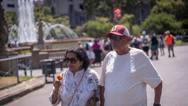 Veïns i turistes busquen refugi a les ombres, s’hidraten i miren de suportar la intensa onada de calor que afecta Barcelona.