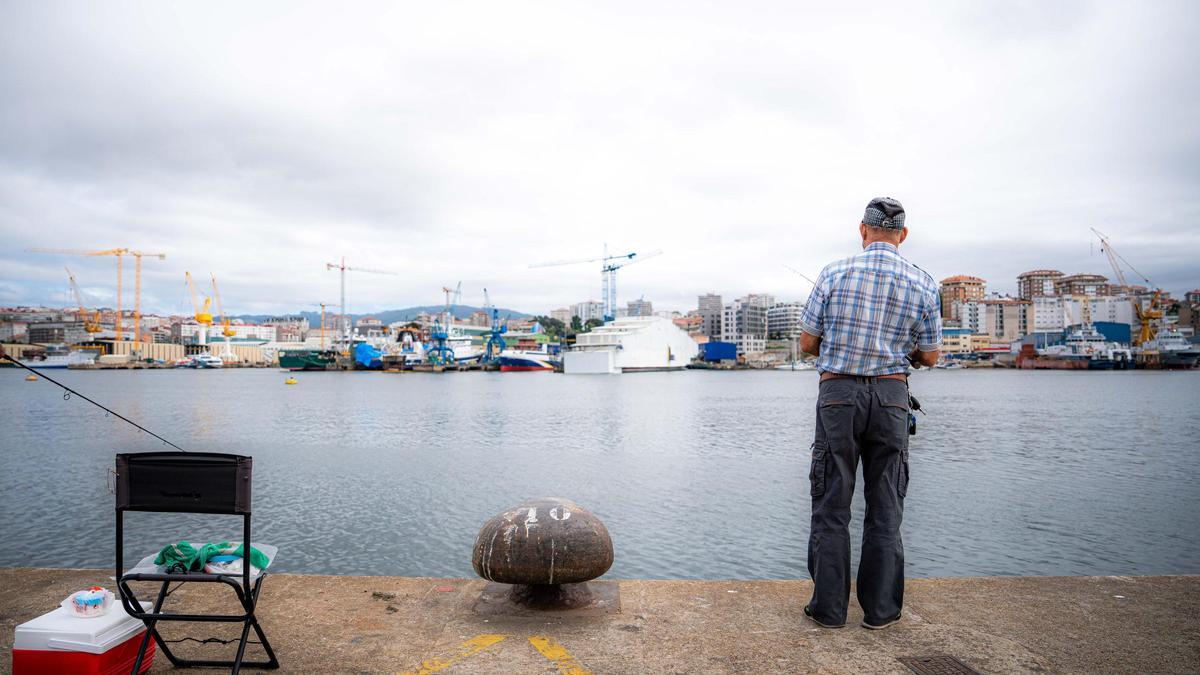 Un jubilado pesca con su caña en la ría de Vigo.