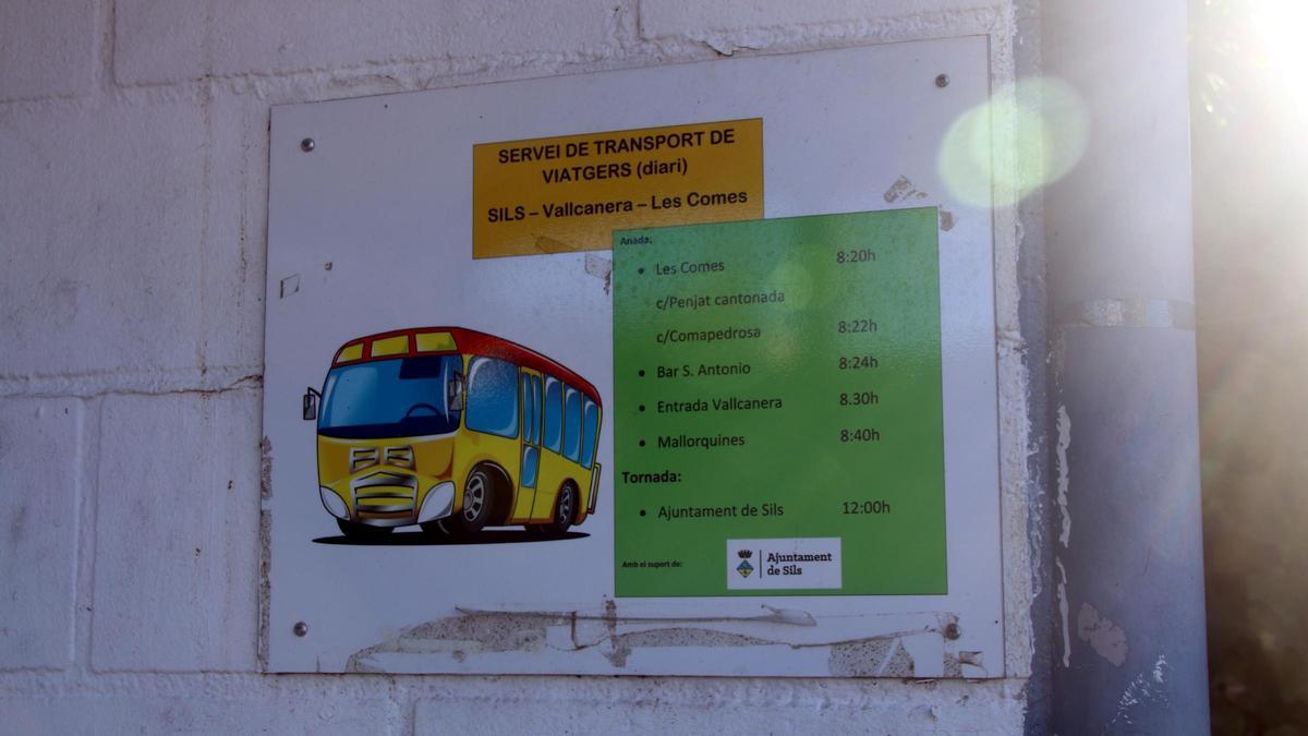 Un cartell anunciant els horaris del transport públic entre urbanitzacions.