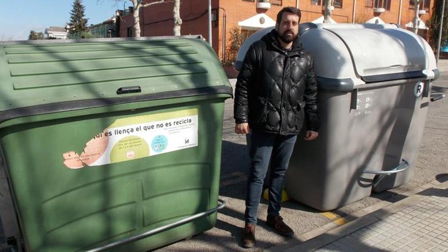 Serracanta entre un contenidor vell, el verd, i els nous, el gris