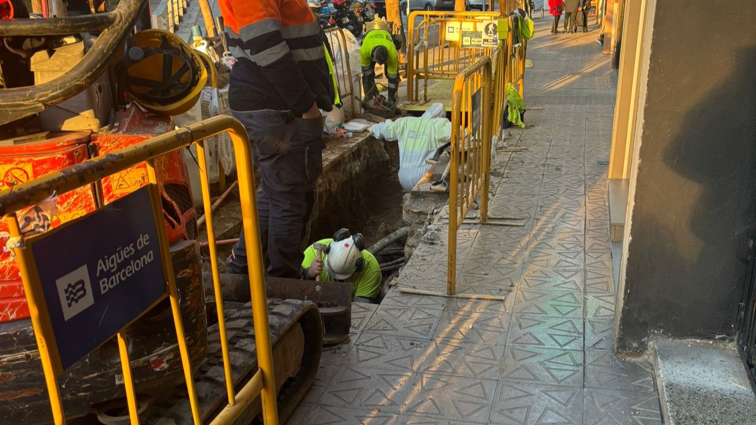 Operarios de Aigües de Barcelona trabajando esta tarde en el punto donde presuntamente se ha originado la avería que ha dejado sin agua a vecinos del distrito de Sant Martí.