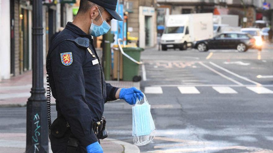 Un agente de policía en A Coruña durante un reparto de mascarillas.