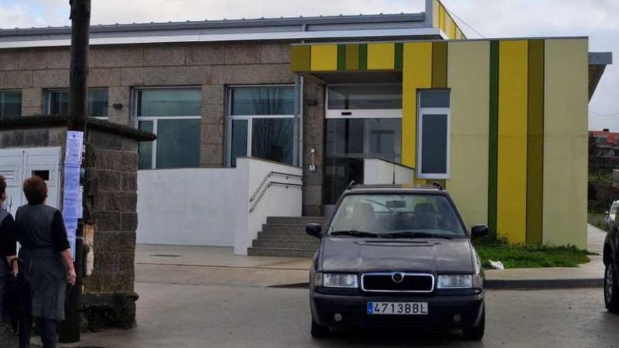 Dos mujeres leen unas esquelas pegadas en un poste eléctrico, frente al centro de día. // Iñaki Abella