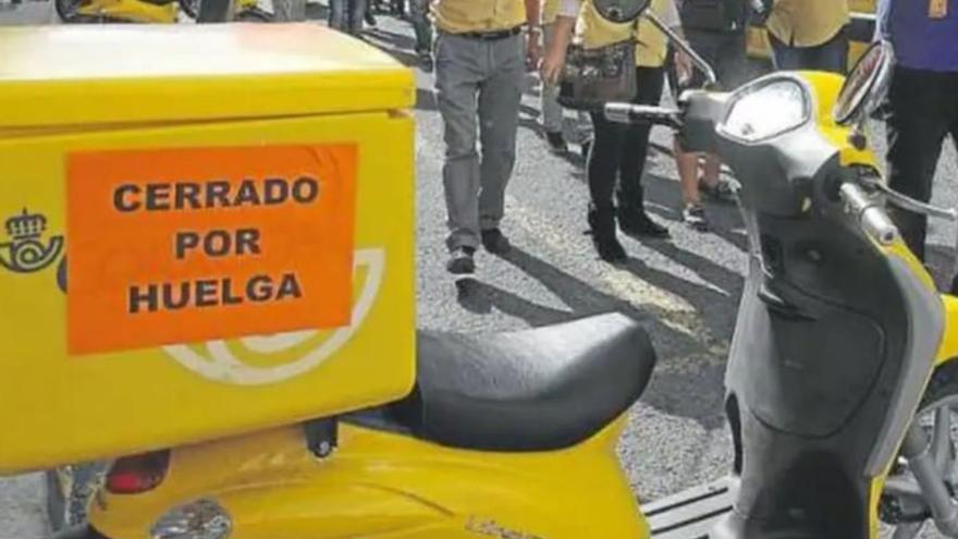 Una moto de reparto postal con un cartel anunciando la huelga del servicio.