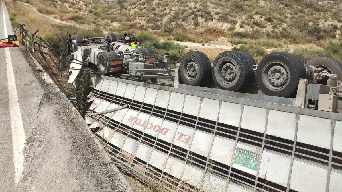 Los bomberos intentan excarcelar al camionero, que se encuentra en el interior de la cabina.