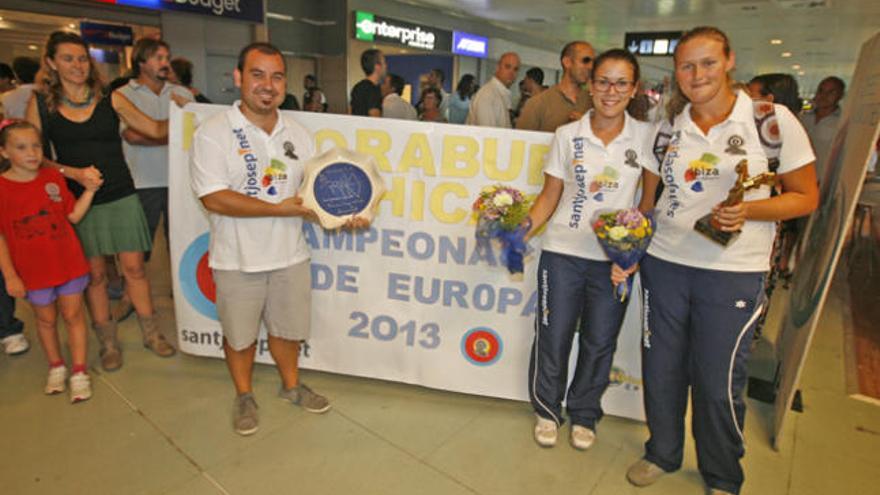 Isabel Colomar y Magali Foulon, ayer a su llegada a la isla. A su derecha, el entrenador José Raúl Riera posa con el trofeo continental.