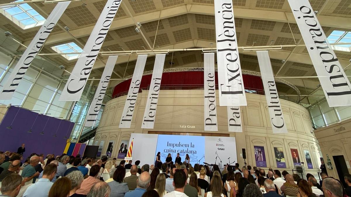 Unas enormes banderas que reproducían palabras que se asocian a la 'cuina catalana' han adornado la presentación en el TNC del plan de acción para el impulso de la cocina catalana.