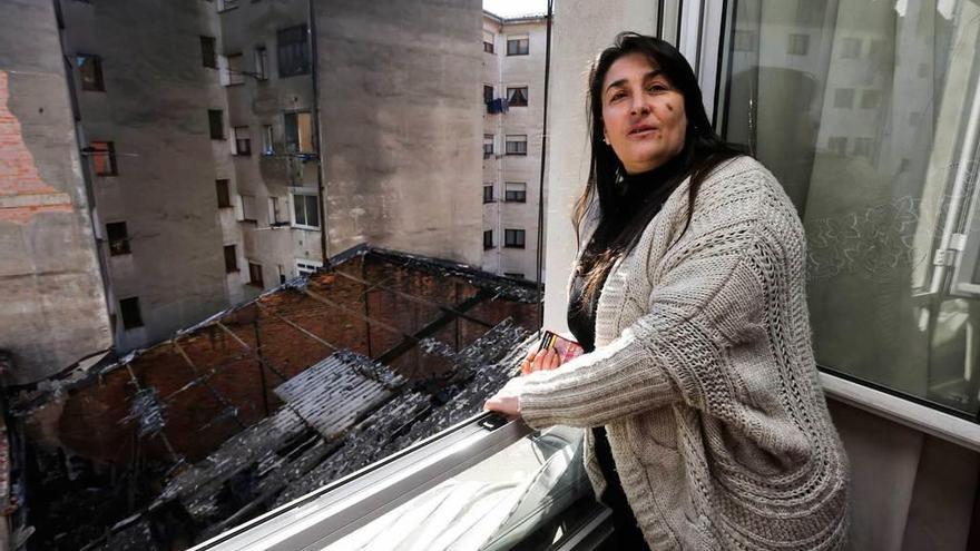 Montse Añón, ayer, junto a una ventana de su casa que da al almacén incendiado del bazar chino.