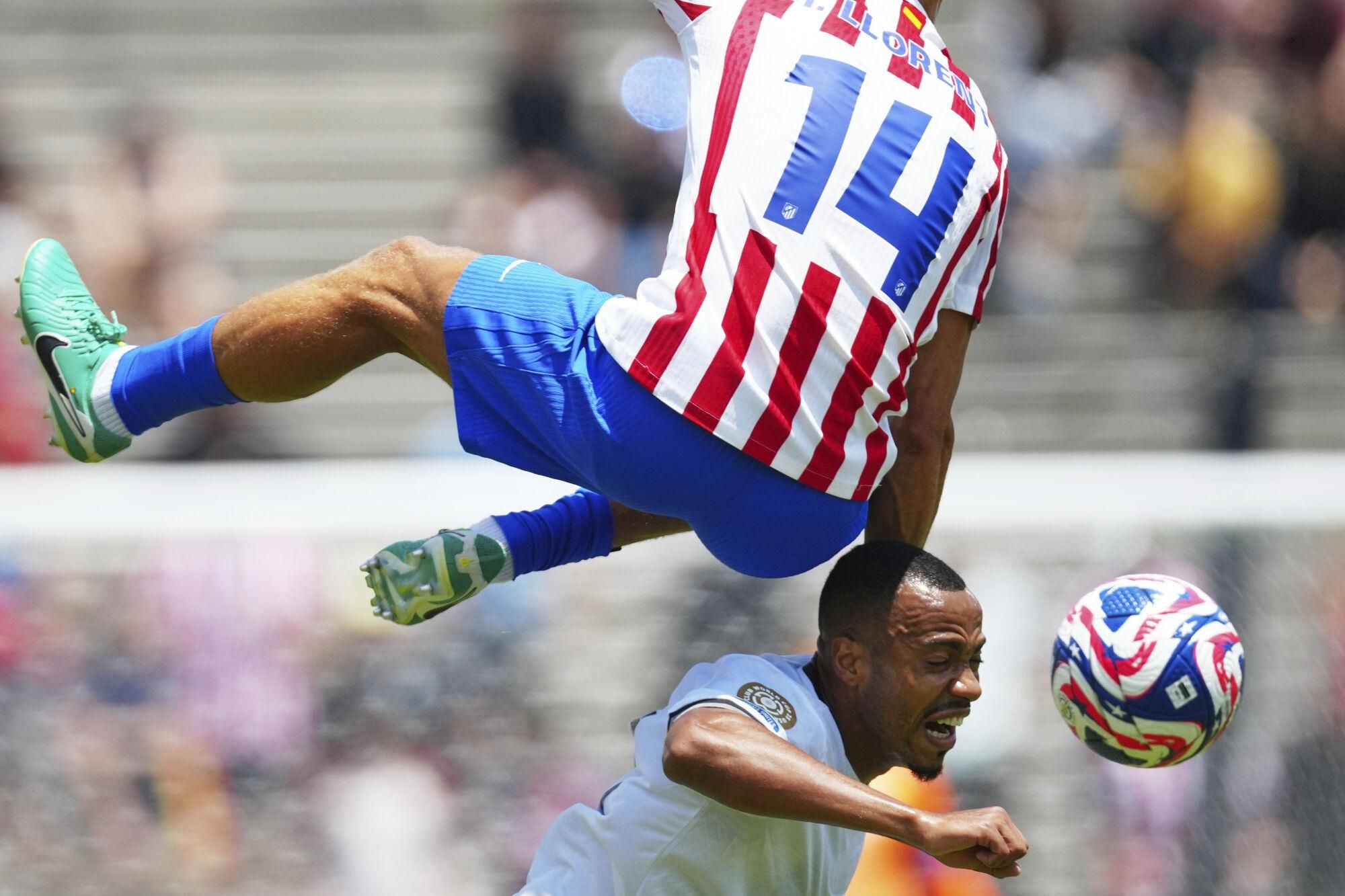 Botafogo's Marlon Freitas, bottom, heads a ball next to Atletico Madrid's Marcos Llorente during the Club World Cup Group B soccer match between Atletico Madrid and Botafogo in Pasadena, Calif., Monday, June 23, 2025. (AP Photo/Jae Hong)