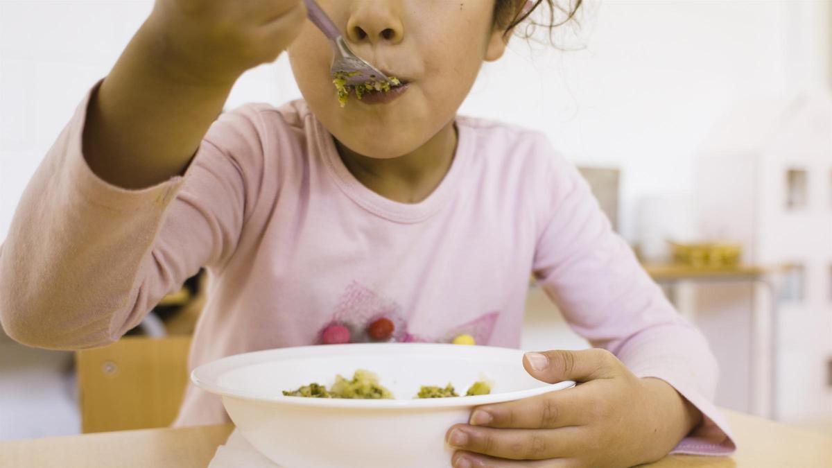 Una niña en un comedor escolar.
