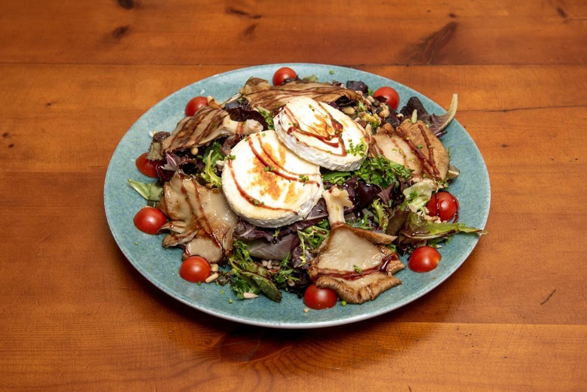 En salada templada de setas y queso de cabra.