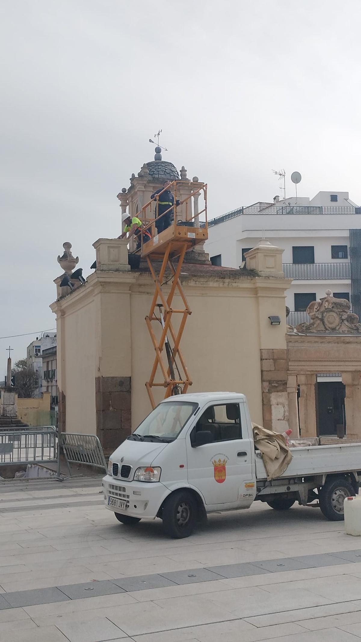 Operarios trabajan con una plataforma elevadora en lo alto del Hornito de Santa Eulalia de Mérida para recolocar las cráteras ya restauradas.