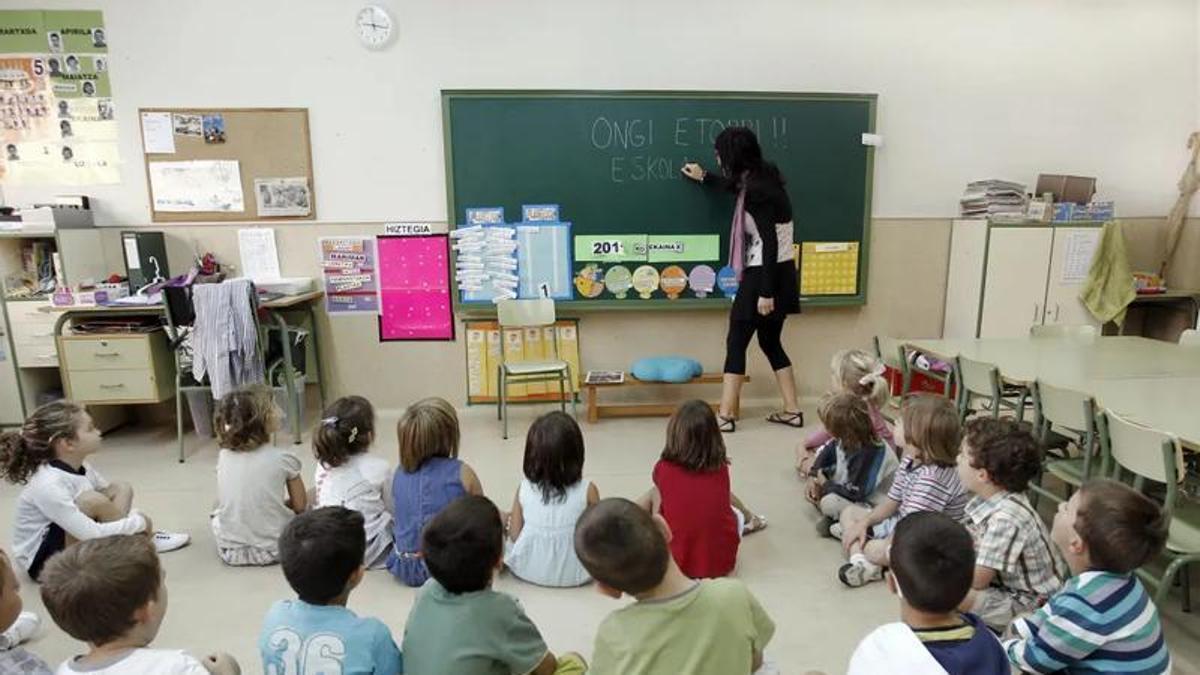 Una profesional atiende a un grupo de escolares durante una actividad en el aula.
