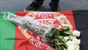 Flores sobre una bandera de Afganistán durante una manifestación contra los ataques con drones en el país asiático