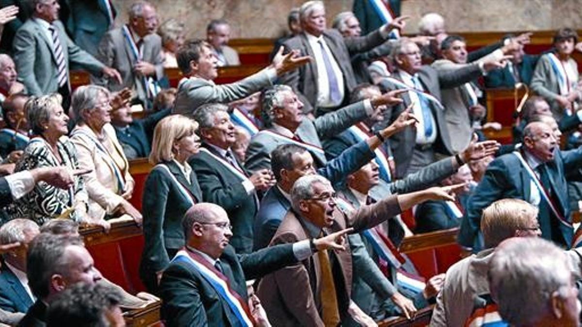 Protestas de los diputados franceses ayer en la sesión de la Asamblea Nacional, donde se aprobó la reforma de las pensiones.