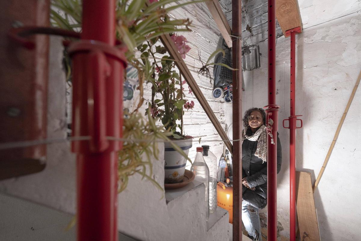 Avelina, vecina de Trinitat Vella, en una escalera apuntalada en el barrio, en Barcelona.